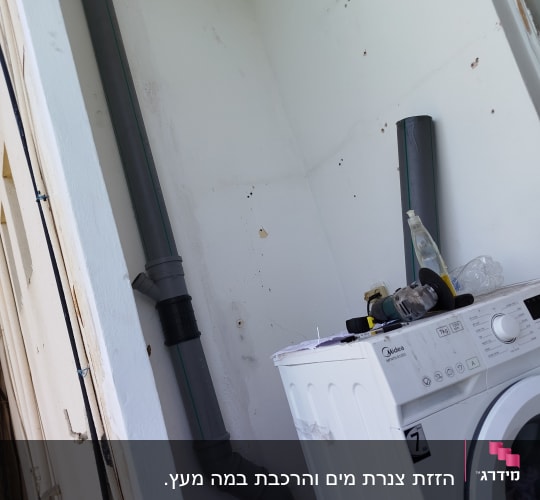 צינור פלסטיק וכלי עבודה ליד מכונת כביסה